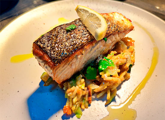 Lombo de salmão grelhado com legumes salteados e limão.